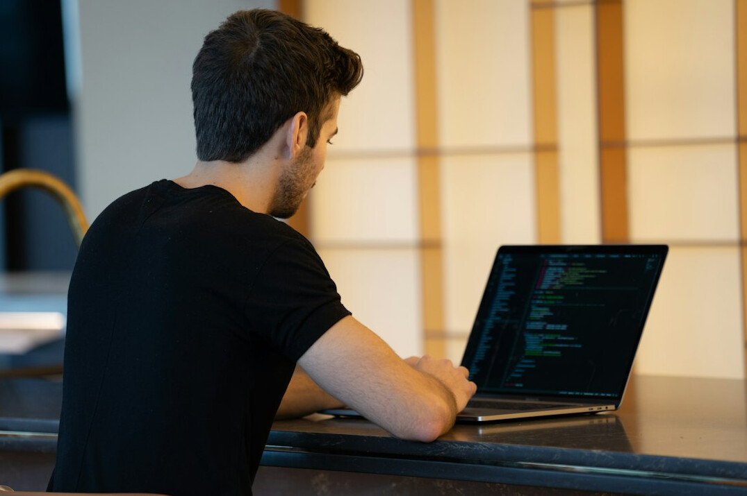 programmer coding on laptop