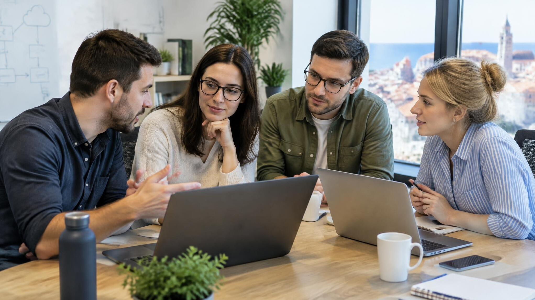 Colleagues discussing a project around a laptop